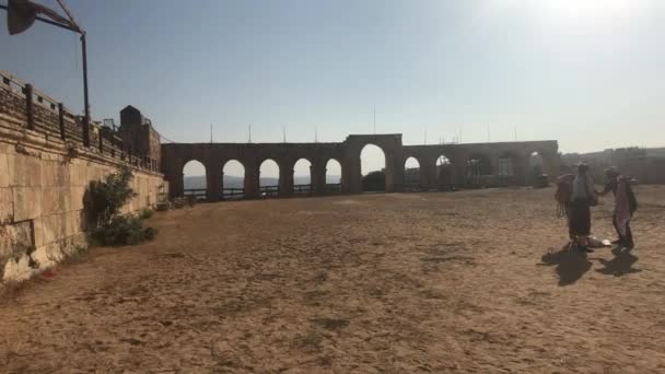 Jerash, Jordanië - 15 oktober 2019: toeristen lopen door de ruïnes van het oude stadsdeel 16 — Stockvideo