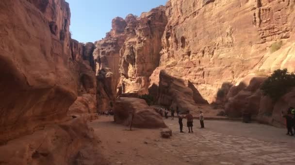 ペトラ,ヨルダン- 2019年10月17日:観光客は岩の部分2の古代の建物の遺跡を探索します — ストック動画