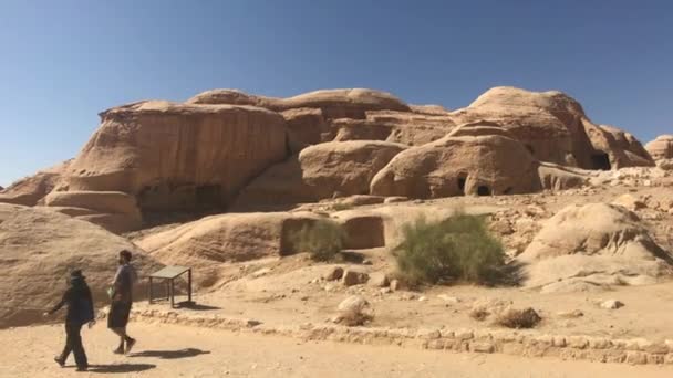 Петра, Иордания - 17 октября 2019 года: туристы перемещаются между горами под палящим солнцем части 1 — стоковое видео