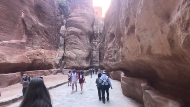 Petra, Jordania - 17 października 2019: turyści biegną wąskimi przejściami między górami część 10 — Wideo stockowe
