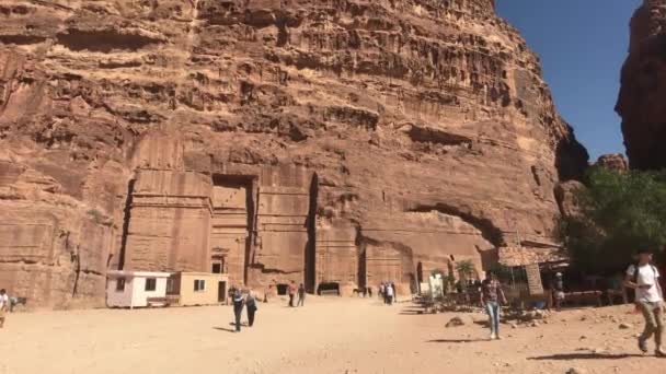Петра, Иордания - 17 октября 2019 года: Туристы исследуют руины древних зданий в скалах, часть 10 — стоковое видео