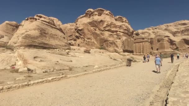 Петра, Иордания - 17 октября 2019 года: Туристы исследуют руины древних зданий в скалах — стоковое видео