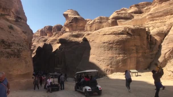 Петра, Иордания - 17 октября 2019 года: туристы передвигаются между горами под палящим солнцем часть 3 — стоковое видео