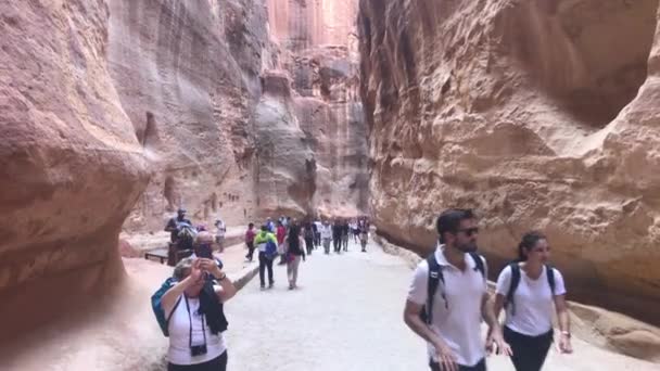 Petra, Jordânia - 17 de outubro de 2019: turistas correm por passagens estreitas entre as montanhas parte 7 — Vídeo de Stock