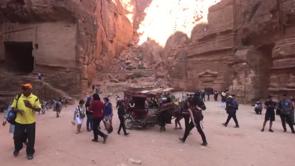Петра, Иордания - 17 октября 2019 года: туристы мчатся по узким проходам между горами часть 16 — стоковое видео
