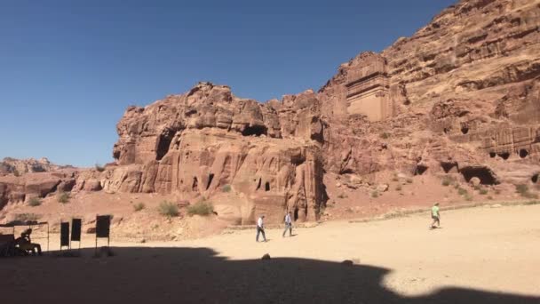 Петра, Иордания - 17 октября 2019 года: Туристы исследуют руины древних зданий в скалах, часть 9 — стоковое видео