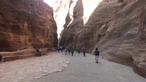 Petra, Jordánsko - 17. října 2019: Turisté prozkoumávají zříceniny starých budov ve skalách část 1 — Stock video