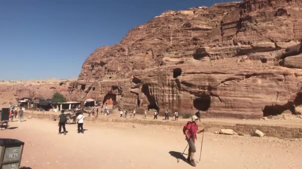Петра, Иордания - 17 октября 2019 года: туристы мчатся по узким проходам между горами часть 18 — стоковое видео