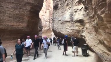 Petra, Ürdün - 17 Ekim 2019: Turistler kavurucu güneşin altında dağların arasında hareket ediyorlar.