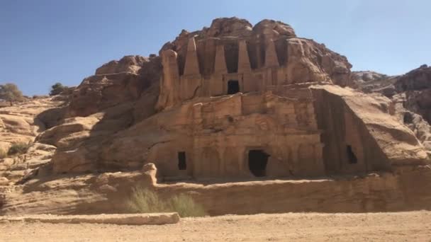 Petra, Jordania - relieves de montaña con estructuras talladas en las rocas — Vídeos de Stock