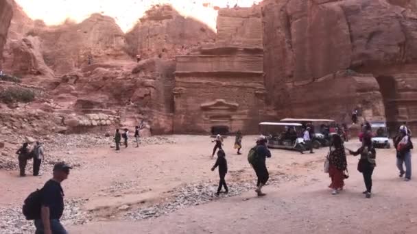 Петра, Йорданія - 17 жовтня 2019: туристи поспішають вузькими проходами між горами 15. — стокове відео