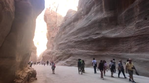 Petra, Jordanien - 17. Oktober 2019: Touristen bewegen sich zwischen Bergen unter sengender Sonne Teil 13 — Stockvideo