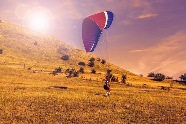 Paraglider over de groene vallei, avondrood — Stockfoto