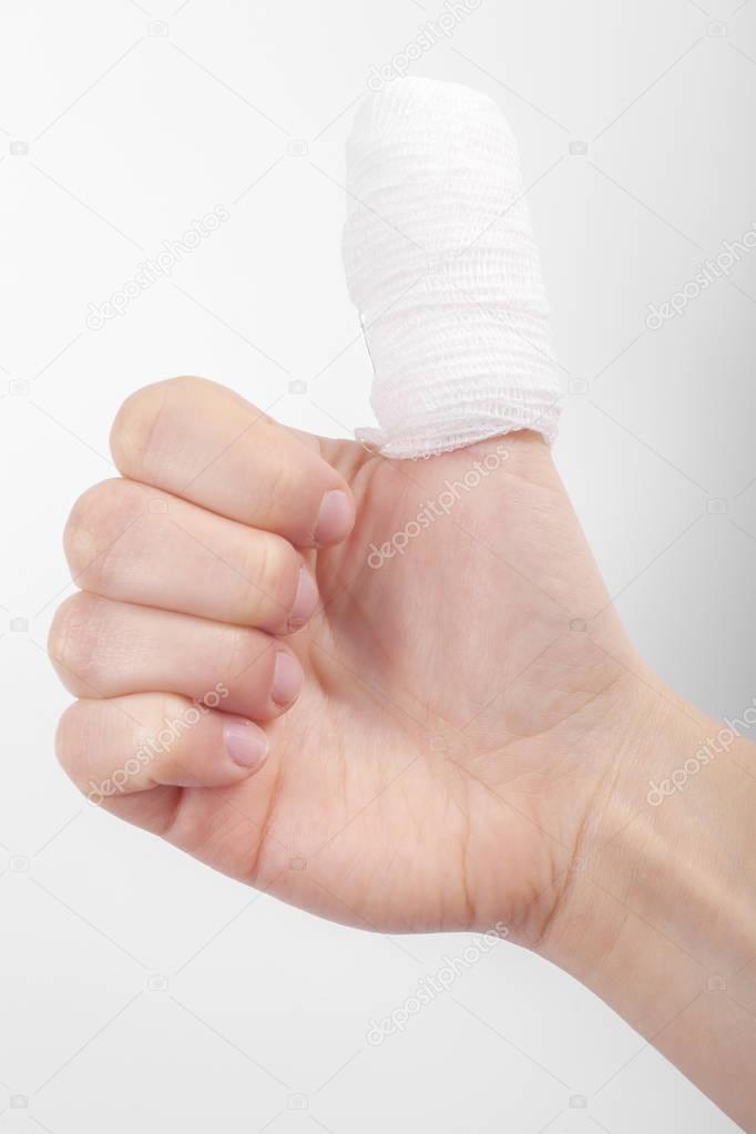 Injured finger with bandage on white background