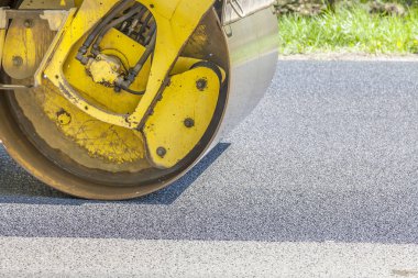 Yol silindiri yeni asfaltı düzleştiriyor