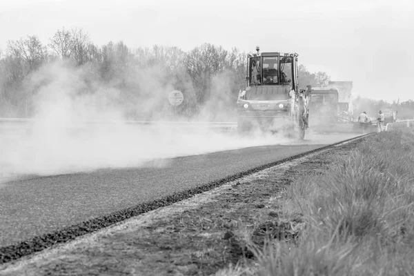 Česká republika, Plzeň, 7 květen, 2016:Asphalt šíření stroj a vibrační válec na chodníku silniční práce. Černobílé fotografie. — Stock fotografie