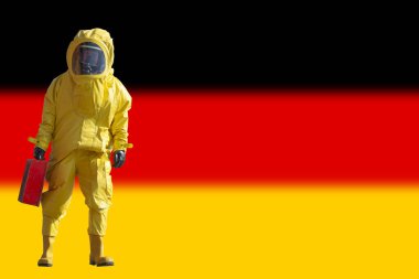 Sarı koruyucu koruyucu koruyucu giysi içinde çantalı izole bir adam. Arka planda Almanya bayrağı. Salgın virüsü..