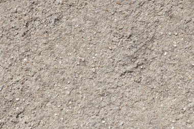 Arka plan dokusu alçıdan gri duvar ve küçük doğal taşlar.