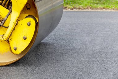 Yol silindiri yeni asfaltı düzleştiriyor