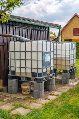 Bahçede yağmur suyu için plastik su tankı 