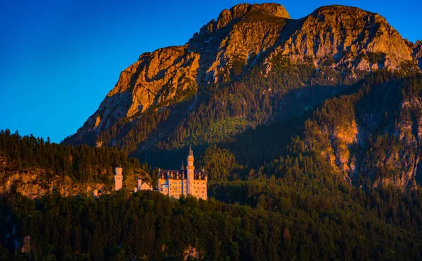 Castelo de Neuschwanstein com vista para a montanha no verão da tarde — Fotografia de Stock