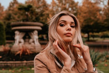 Sarı saçlı, sokak stili, çekici bir genç kadın portresi.