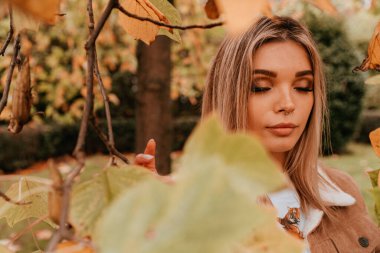 Sarı saçlı, sokak stili, çekici bir genç kadın portresi.