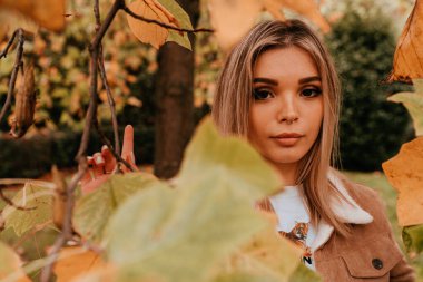 Sarı saçlı, sokak stili, çekici bir genç kadın portresi.