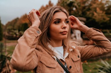 Sarı saçlı, sokak stili, çekici bir genç kadın portresi.