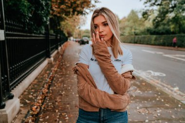 Sarı saçlı, sokak stili, çekici bir genç kadın portresi.