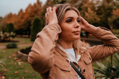 Sarı saçlı, sokak stili, çekici bir genç kadın portresi.