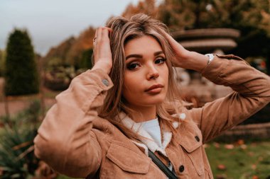 Sarı saçlı, sokak stili, çekici bir genç kadın portresi.