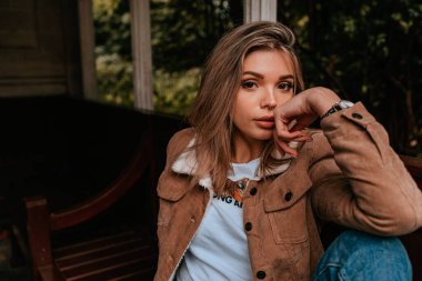 Sarı saçlı, sokak stili, çekici bir genç kadın portresi.