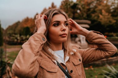 Sarı saçlı, sokak stili, çekici bir genç kadın portresi.