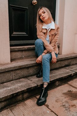 Sarı saçlı, sokak stili, çekici bir genç kadın portresi.