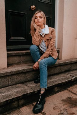 Sarı saçlı, sokak stili, çekici bir genç kadın portresi.