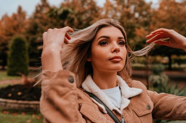 Sarı saçlı, sokak stili, çekici bir genç kadın portresi.