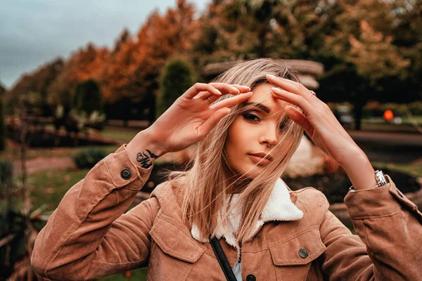 Sarı saçlı, sokak stili, çekici bir genç kadın portresi.