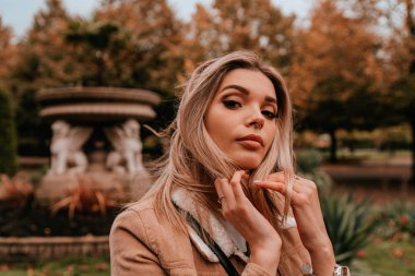 Sarı saçlı, sokak stili, çekici bir genç kadın portresi.