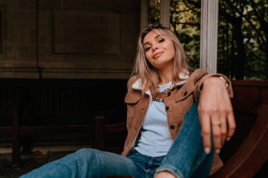 Sarı saçlı, sokak stili, çekici bir genç kadın portresi.