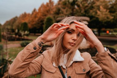 Sarı saçlı, sokak stili, çekici bir genç kadın portresi.