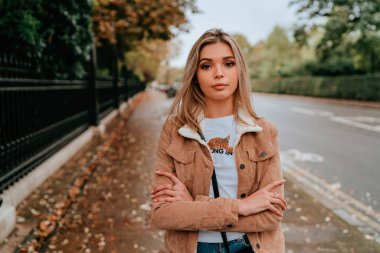 Sarı saçlı, sokak stili, çekici bir genç kadın portresi.