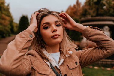 Sarı saçlı, sokak stili, çekici bir genç kadın portresi.