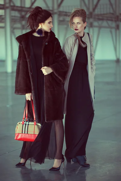 Two models at airport are waiting  private airplane. fashion look, stylish make up, perfect hairdo and interesting individual bags — Stock Photo, Image