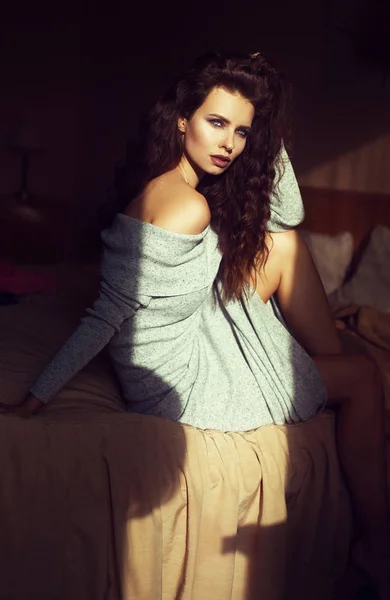 Sexy joven mujer de la moda en la habitación del hotel, descansando después de ir de compras. Luces cálidas suaves en la ventana y en la habitación . — Foto de Stock