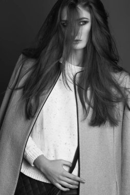 yüksek moda bej bir palto, mavi kot pantolon ve örme kazak zarif kadın portresi. Stüdyo vurdu. Her gün için mükemmel yaşam tarzı giyim kavramı