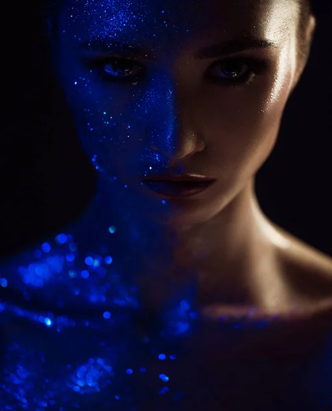Retrato de mujer con maquillaje creativo, una parte de la cara en borlas azules, con lentejuelas brillantes. piel y labios perfectos. Concepto del efecto mágico en la cara —  Fotos de Stock