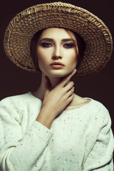 Estilo Hipster. Retrato elegante de uma jovem menina bonita vestindo pulôver de malha branca na moda e chapéu de palha, posando sobre fundo de chocolate retro. Estilo Vogue. Estúdio — Fotografia de Stock