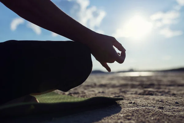 Man practices yoga and meditates in the sport position on the beach — Stock Photo, Image