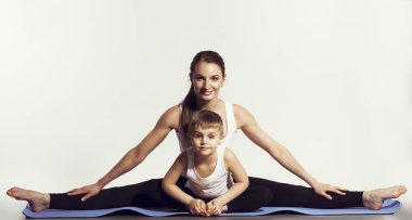 Anne ve oğlu (spor egzersizleri), yoga yaparken eğlenmek ve birlikte iyi vakit geçirmek. beyaz izole. sağlıklı bir yaşam tarzı kavramı